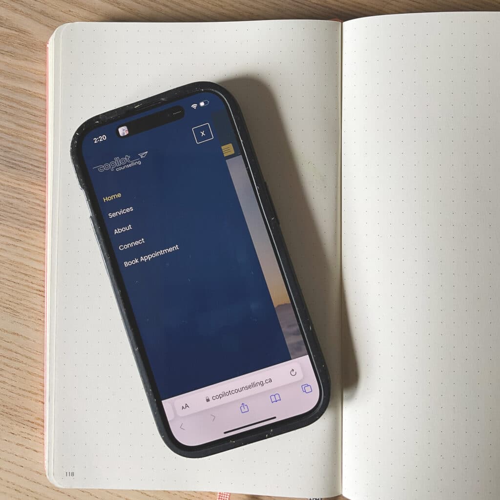 iPhone on a notebook with a website pop out menu displayed